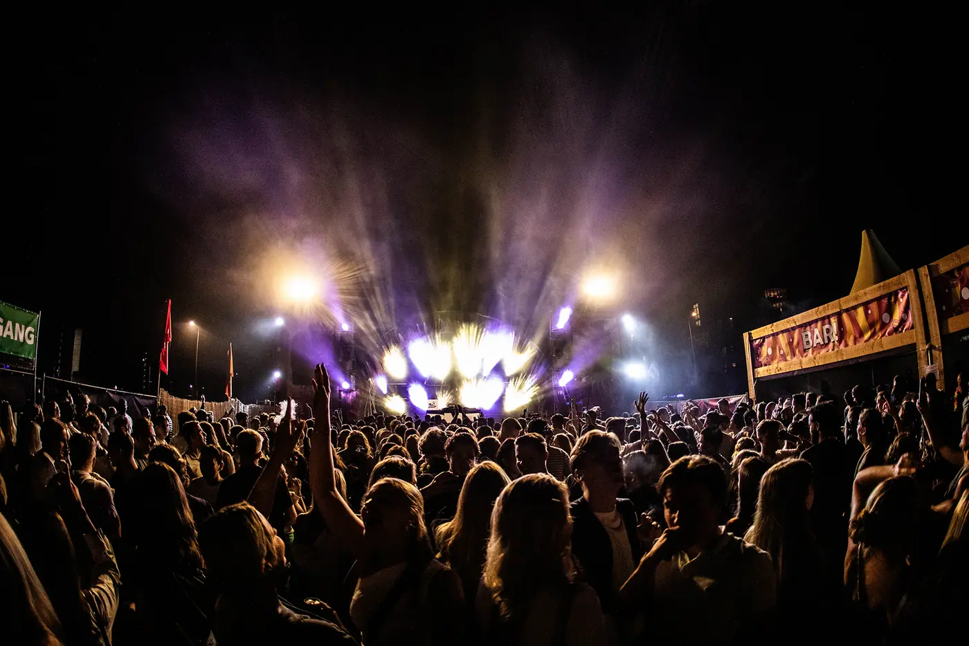 De mainstage van Stadsliefde Festival bij avond, met licht boven een vol publiek